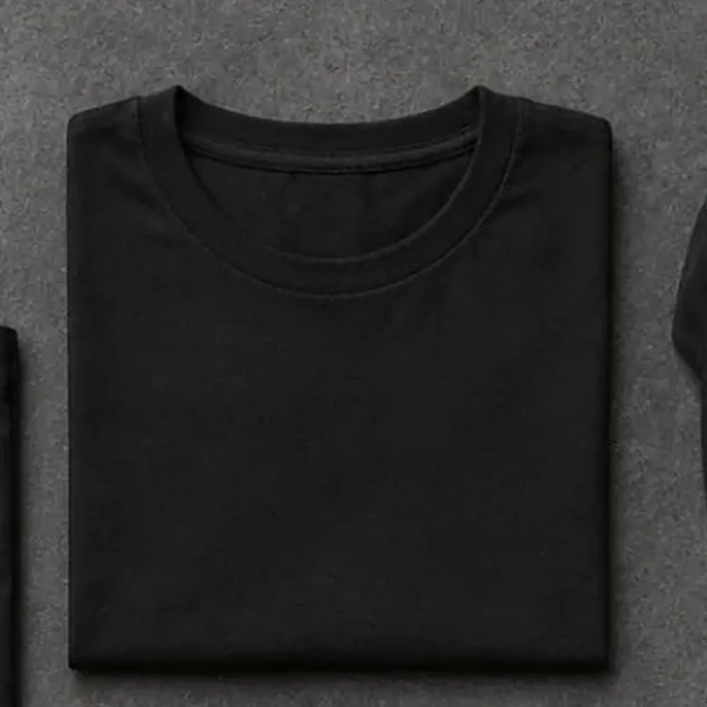 Folded black t-shirt with a chest badge