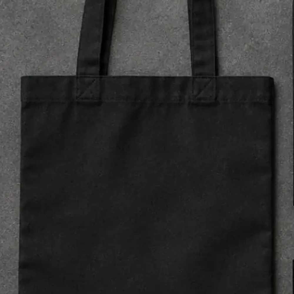 Black canvas tote bag with a badge
